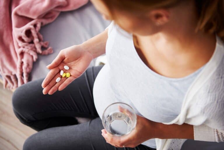 młoda kobieta w ciąży zażywa leki